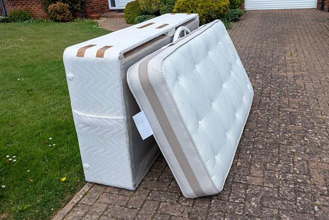 a truck hauling away a discarded mattress